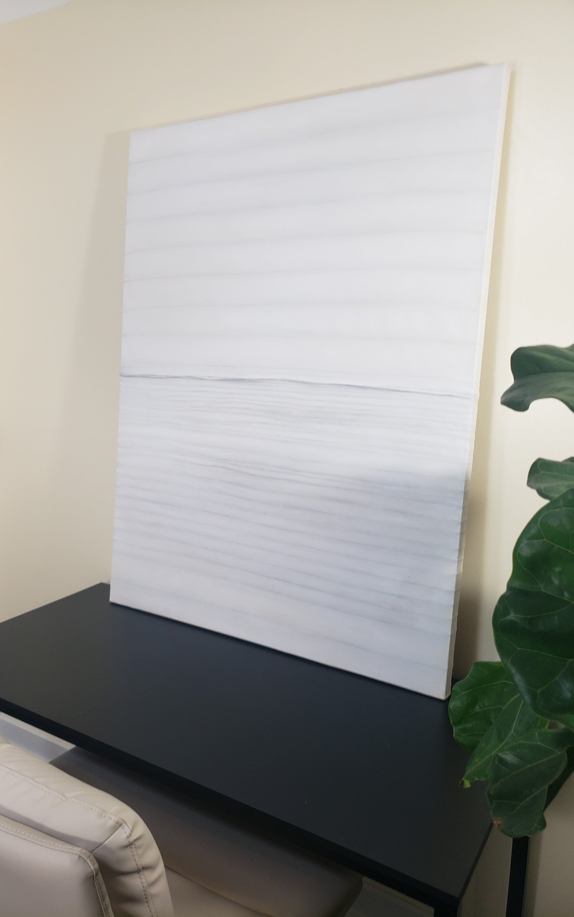 Stitched Horizon 01 painting by Carrie Bergey leaning on a black desk, emphasizing its soft stitched textures and minimalist mixed media design.